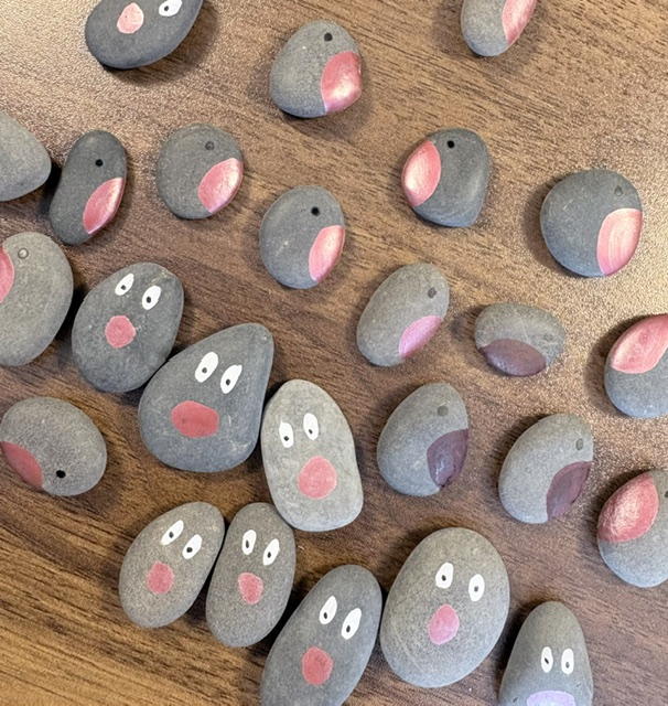 Hand-painted pebble robins and reindeer being made for Christmas gift tags.