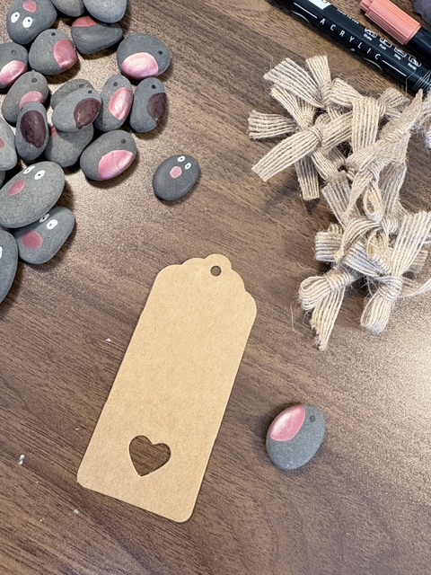Pebble robins, wooden gift tag and hessian bows laid out ready to make Christmas gift tags.